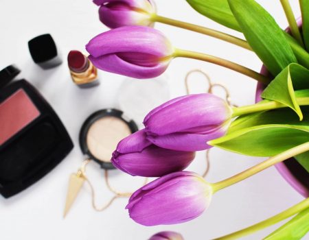 tulipanes color violeta al lado de productos de maquillaje para ilustrar cuando caduca el maquillaje